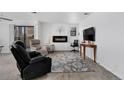 Cozy living room with fireplace, balcony access and gray floral rug at 10950 W Florida Ave # 303, Lakewood, CO 80232