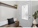 Inviting entryway features a storage bench with coat hooks, and a door with decorative glass for natural light at 1996 W 66Th Ave, Denver, CO 80221