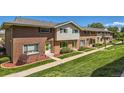 Wide shot of brick townhomes with lush green lawns and well-kept landscaping at 9263 E Nassau Ave, Denver, CO 80237