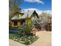 A charming yellow house with blue trim surrounded by green foliage at 2320 22Nd St, Boulder, CO 80304