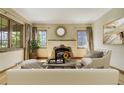 Bright living room with a decorative fireplace, hardwood flooring, and a comfortable seating arrangement at 2285 N Monaco Pkwy, Denver, CO 80207