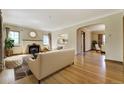 Spacious living room with hardwood floors, fireplace, and seamless flow to dining area at 2285 N Monaco Pkwy, Denver, CO 80207