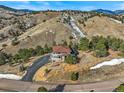 Expansive aerial view of a home nestled within a densely treed area with a long driveway at 457 Buena Vista Rd, Golden, CO 80401