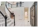Spacious foyer featuring a staircase, tile flooring, and an open view of the upper level at 7420 S Houstoun Waring Cir, Littleton, CO 80120
