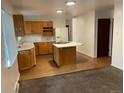 Open kitchen featuring wood cabinetry, an island cooktop, and updated appliances at 4115 S Vincennes Ct, Denver, CO 80237