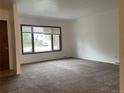 Bright, open living room featuring new carpeting and a large window for natural light at 4115 S Vincennes Ct, Denver, CO 80237