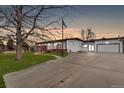 Ranch home with large driveway and attached garage, with a yard and mature tree at 940 S Geneva St, Aurora, CO 80247