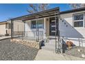 Exterior of home with white siding, decorative black metal porch cover and railing plus stone foundation accent at 4611 W 2Nd Ave, Denver, CO 80219