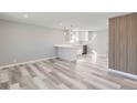 Bright kitchen open to dining area features white cabinets, modern appliances and plank vinyl flooring at 4611 W 2Nd Ave, Denver, CO 80219