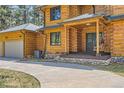 Log home's entrance with a covered porch and stone accents at 7350 Fremont Pl, Larkspur, CO 80118