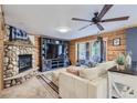 Cozy living room featuring a stone fireplace and large TV at 7350 Fremont Pl, Larkspur, CO 80118