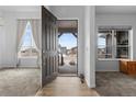 Inviting entryway featuring hardwood floors, and sunlit living spaces through an open door, connecting the interior to the outdoors at 22580 E Eads Cir, Aurora, CO 80016