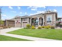 Charming home featuring a well-manicured lawn, stone accents, a two-car garage, and inviting front porch at 22580 E Eads Cir, Aurora, CO 80016