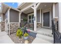 Inviting front porch with decorative plants, stone accents, and a cozy seating area at 22580 E Eads Cir, Aurora, CO 80016