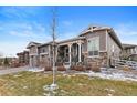 Beautiful home with stone accents and landscaping with green grass and inviting front porch at 22580 E Eads Cir, Aurora, CO 80016