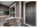 Cozy covered porch with chairs, table and lovely stone accents, perfect for enjoying quiet moments outdoors at 22580 E Eads Cir, Aurora, CO 80016