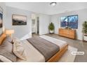 Virtually staged main bedroom with a dresser, large bed, and en-suite bathroom at 9010 W 88Th Cir, Westminster, CO 80021