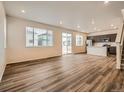Bright, open living space with sleek hardwood flooring, recessed lighting, and stainless steel appliances at 553 Homestead Ave, Brighton, CO 80601