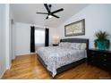 Serene primary bedroom with hardwood floors, ceiling fan, and a large window at 17145 Park Trail Dr, Monument, CO 80132