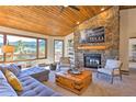 Cozy living room with stone fireplace and mountain views at 6220 Arapahoe Dr, Evergreen, CO 80439