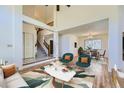 Bright living room featuring high ceilings, neutral decor, hardwood floors and staircase with adjacent dining area at 5331 S Dunkirk Way, Centennial, CO 80015