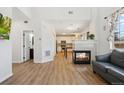 Bright living room with open floor plan, wood floors, fireplace, and connection to the updated kitchen at 7453 S Norfolk St, Aurora, CO 80016