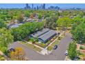 A high-angle aerial view showcases the property's proximity to lush greenery and the distant city skyline at 2955 N Gilpin St, Denver, CO 80205