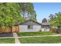 Cozy exterior of a home showcasing its gray brick facade and lush green lawn at 2955 N Gilpin St, Denver, CO 80205