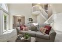 Cozy living room features modern decor and an open layout with staircase and dining area at 9564 Cordova Dr, Highlands Ranch, CO 80130