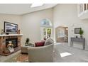 Inviting living area with brick fireplace and access to dining room and backyard patio at 9564 Cordova Dr, Highlands Ranch, CO 80130