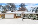 Ranch-style home with a brick and siding exterior, two-car garage, and a snow-covered lawn at 2842 S Newport St, Denver, CO 80224