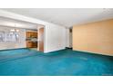 Spacious living room with bold blue carpeting, light-colored walls, and an open floor plan at 2842 S Newport St, Denver, CO 80224