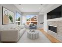 Bright living room featuring hardwood floors, large windows, and a stone fireplace at 1284 Tennyson St # 1, Denver, CO 80204