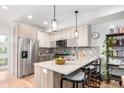 Contemporary kitchen featuring stainless steel appliances, light wood cabinets, and an inviting breakfast bar with stylish pendant lighting at 1941 Hooker St, Denver, CO 80204