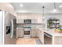 Modern kitchen with stainless steel appliances, sleek cabinets, mosaic backsplash, and hardwood floors for a contemporary touch at 1941 Hooker St, Denver, CO 80204