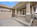 Close-up of the front porch of a brown home with stone accents and a two car garage at 4400 S Ensenada St, Aurora, CO 80015