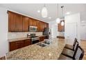 Bright kitchen with stainless steel appliances, granite countertops, and ample cabinet space at 4400 S Ensenada St, Aurora, CO 80015