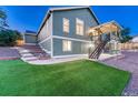 Grassy backyard with steps leading up to a covered deck at 1838 Mountain Daisy Ct, Highlands Ranch, CO 80129