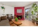 Cozy living room with a brick fireplace, comfortable seating, and access to a private balcony at 1390 Everett Ct # 220, Lakewood, CO 80215