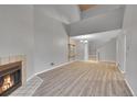 A well-lit living room with a fireplace, high ceiling, wood floors, and adjacent staircase at 11101 E Alameda Ave # 202, Aurora, CO 80012