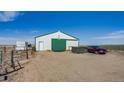 Exterior view of barn with green trim and a car parked nearby at 16491 County Road 32, Platteville, CO 80651