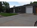 Brick home with a spacious driveway, garage, and a well-maintained front yard with solar panels at 5585 W 51St Pl, Denver, CO 80212