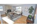 Inviting living room with hardwood floors, stone fireplace, and large window at 5585 W 51St Pl, Denver, CO 80212