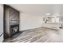 Open-concept living space featuring a fireplace, gray flooring, and seamless flow to the kitchen at 9618 W Chatfield Ave # B, Littleton, CO 80128