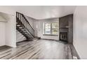 Bright living room with sleek gray floors, a modern fireplace, and staircase at 9618 W Chatfield Ave # B, Littleton, CO 80128