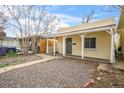 Quaint home with covered porch, security door, and low-maintenance gravel yard at 4764 High St, Denver, CO 80216