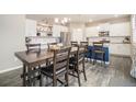 Open kitchen with a dark wood table, stainless appliances, and white cabinets at 8395 E 132Nd Pl, Thornton, CO 80602