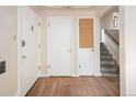 Bright foyer with wooden floors, three doors, and stairs going to the upper level at 3860 Dudley St, Wheat Ridge, CO 80033