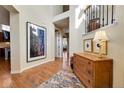 Inviting foyer with hardwood floors, elegant décor, and an open staircase at 9351 Viaggio Way, Highlands Ranch, CO 80126