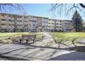 Apartment building with a well-maintained lawn and mature trees at 650 S Clinton St # 11B, Denver, CO 80247